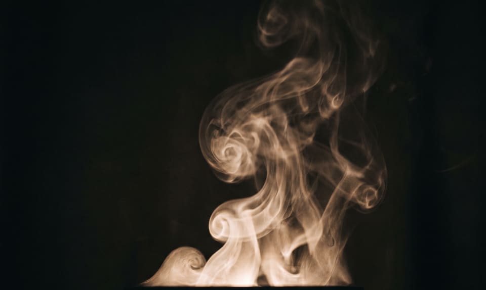 Warm white steam curling upward against a dark background.